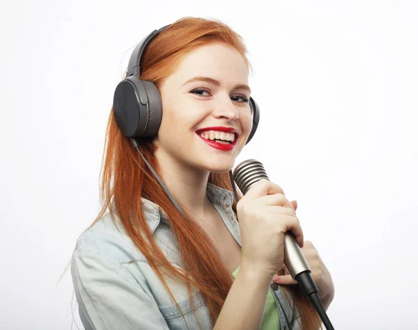 Cheerful Young Red Haired Woman Wearing Headphones Holding Microphone Singing — Foto de Stock