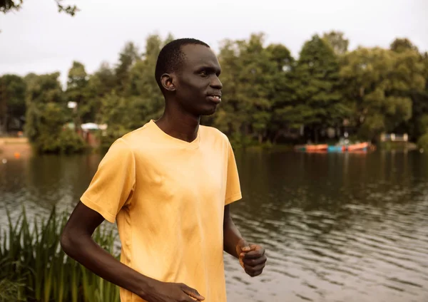 Young Black Man Yellow Shirt Jogging Lake Morning Summer Day — Stok fotoğraf