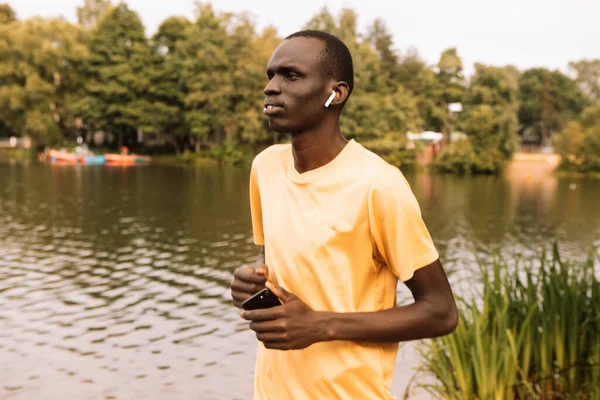 Joven Negro Con Una Camiseta Amarilla Está Trotando Cerca Lago —  Fotos de Stock