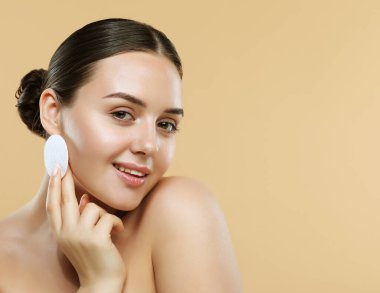 Güzellik mankeni kusursuz cildini pamuklu süngerle temizliyor, yakın plan. Genç bir kadın yüzünü önemser. Spa ve Sağlık, Cilt Bakımı Konsepti.