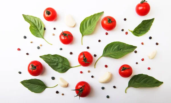 Tomato cherry, basil, spices, pepper. Fresh organic tomatoes, isolated on white. Vegan veggies diet food. Basil, herb and cherry tomatoes, cooking concept, top view.