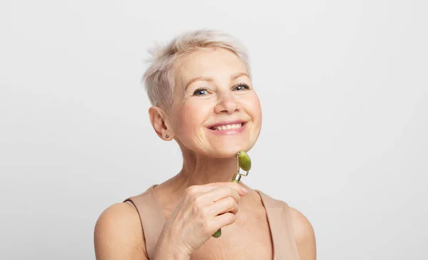 Gorgeous Woman 60S Massaging Face Skin Using Natural Facial Stone — Stock Photo, Image