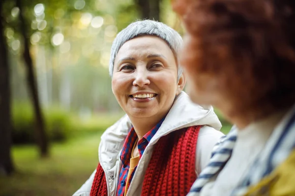 Vidám Nyugdíjas Női Barátok Beszélgetnek Nevetnek Őszi Parkban Életmódbeli Kókusz — Stock Fotó