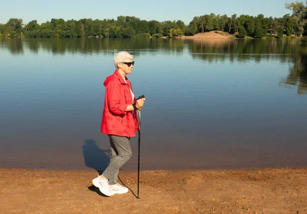 Šedovlasá Žena Červené Bundě Kráčející Stopkami Pláži Jezera Letní Den — Stock fotografie