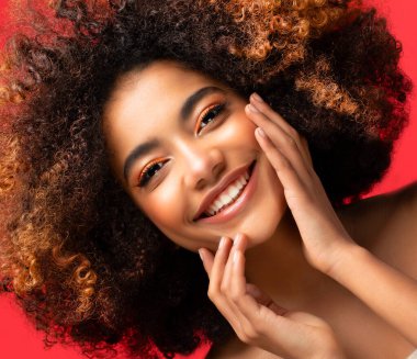 Kırmızı arkaplanda izole edilmiş koyu tenli bir kadın var..