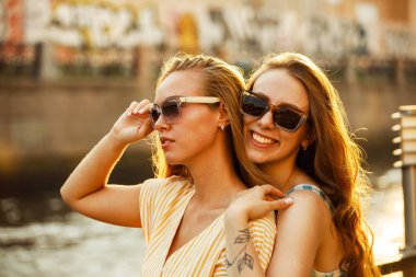 Gökyüzü arka planında birlikte poz veren kadınlardan esinlendim. Kafkasyalı kadınların güzel bir günün tadını çıkarırken çekilmiş açık hava fotoğrafı..