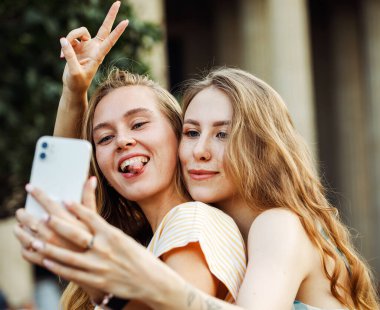 Şehirde selfie çeken iki mutlu genç kadın. Yaz günü. Arkadaşlık kavramı. Genç bayan arkadaş mutluluğu.
