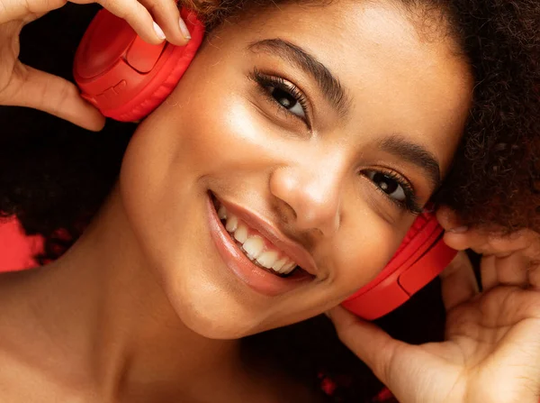 stock image People, music, emotions concept. Young afro american female with dances in rhythm of melody. Portrait over red color background.