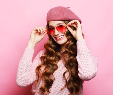 Onun güzel görünüşlü portresi... güzel... sevimli... sevimli... sevimli... neşeli... neşeli... dalgalı saçlı... pembe renkli arka planda izole edilmiş bir kadın.