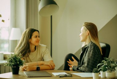 İyi ilişkileri olan samimi kadın meslektaşları gülümseyen genç kadın kahve tatilinde işyerinde hoş sohbet dinle ofisinde konuşmaya yeni proje, tartışırken konuşkan iş arkadaşınız,