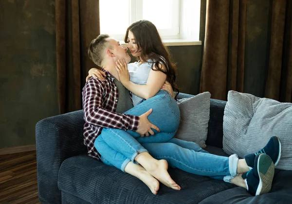 年轻漂亮的夫妇正坐在沙发上拥抱 快乐的家庭生活爱 — 图库照片