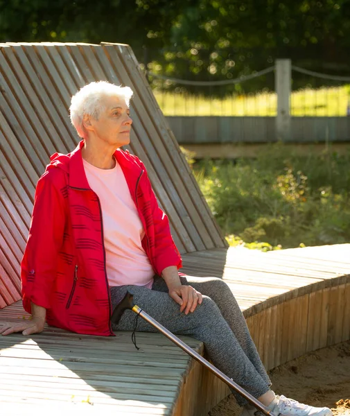 Пожилая Женщина Короткими Седыми Волосами Сидит Деревянной Скамейке Парке Концепция — стоковое фото