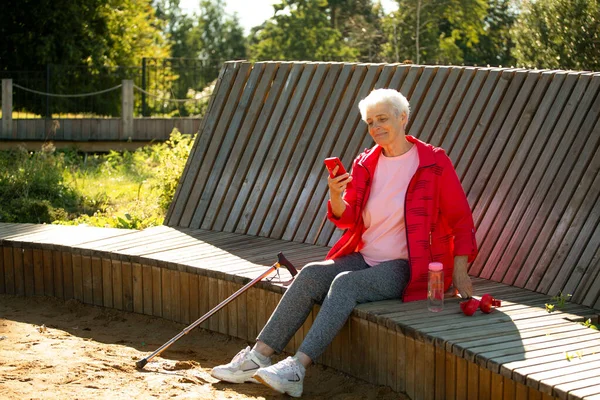 Starší Žena Krátkými Šedými Vlasy Sedí Dřevěné Lavičce Parku Dívá — Stock fotografie