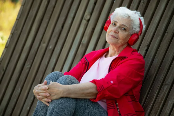 Starší Žena Krátkými Šedými Vlasy Sedí Dřevěné Lavičce Parku Poslouchá — Stock fotografie