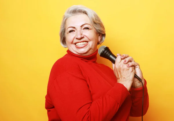 Szczęśliwa Seniorka Śpiewająca Mikrofonem Bawiąca Się Wyrażająca Talent Muzyczny Żółtym — Zdjęcie stockowe