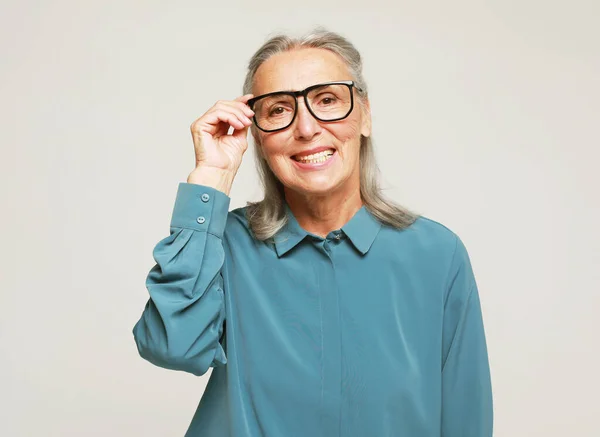 Ηλικιωμένη Χαμογελαστή Γυναίκα Κοιτάζει Μέσα Από Γυαλιά Της — Φωτογραφία Αρχείου