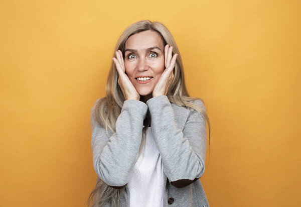 Стиль жизни, эмоции и понятие людей: пожилая удивительная женщина. Изолированный на жёлтом фоне.