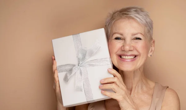 Photo Smiling Lady Pensioner Short Hair Holding Present Box Isolated — Stock Photo, Image