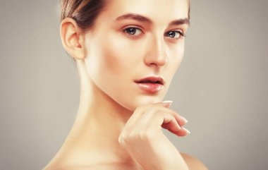 Sağlıklı ciltli, genç ve çekici bir kadının yakın plan portresi. Temiz tenli beyaz bir kadının güzel yüzü. Cilt bakımı kavramı.