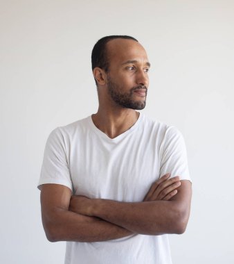 Portre genç afro Amerikan modeli ayakta kolları olan beyaz arka planı geçti gülüyor ve uzak kopya alanı seyir