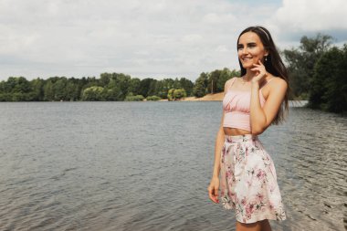 Güzel, modaya uygun bir kadın. Yaz parkında poz veren genç bir manken. Portreyi kapat.