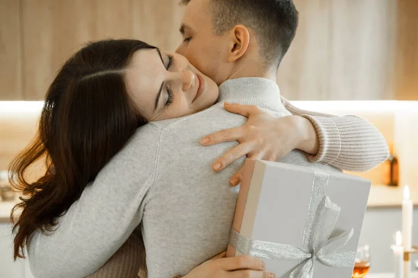 Jovem Atraente Com Caixa Presente Abraçando Seu Namorado Casa — Fotografia de Stock
