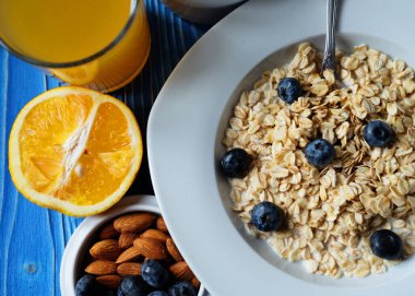 Sağlıklı kahvaltı, yemek ve diyet konsepti - taze böğürtlenli yulaf ezmesi ile portakal suyu, üst görünüm