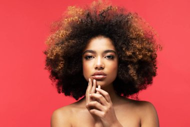 Afro saçlı, güzel, Afro-Amerikan bir kadın. Kırmızı Arkaplan.
