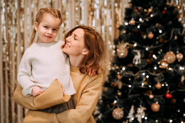 Young Mother Holds Laughing Daughter Her Arms Next Christmas Tree — Stock Photo, Image