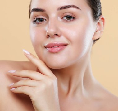 Parlak fosforlu kalemleri ve parlak dudaklarıyla çenesine dokunan genç esmer kadın, doğal makyajlı ve mükemmel saç stili olan güzel kadın. Güzellik konsepti.