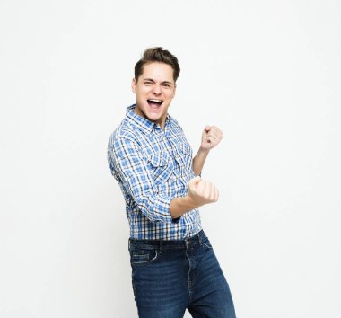 İnsanlar, duygu ve mutluluk kavramı: Genç adam beyaz arkaplan üzerindeki zaferini kutluyor