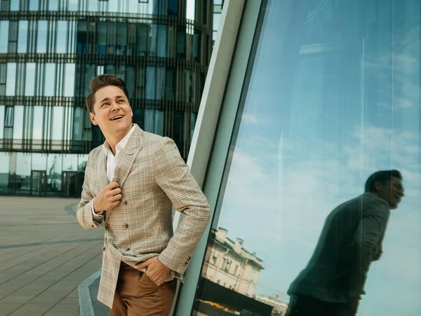 ビジネス ライフスタイルのコンセプト バックグラウンドのオフィスビルで屋外を歩いている間 ハンサムな若いビジネスマン — ストック写真