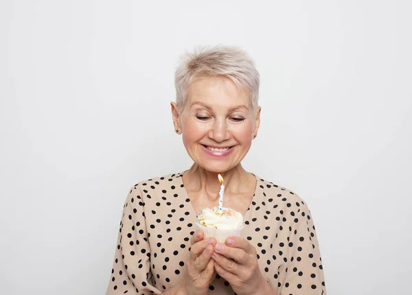 Glada Äldre Kvinna Med Kort Frisyr Håller Cupcake Med Ett — Stockfoto