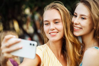 Şehirde selfie çeken iki mutlu genç kadın. Yaz günü. Arkadaşlık kavramı.