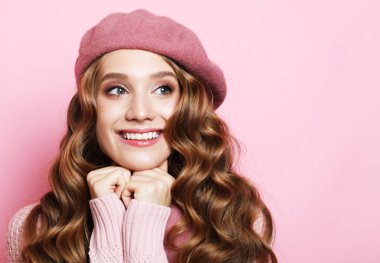 Pembe arka planda pembe bereli uzun dalgalı saçlı güzel bir kadın.