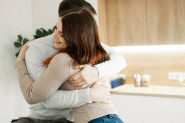 Genç aşık çift mutfakta kırmızı şarap içiyor. Rahat bir ev. Aşk ve romantik.