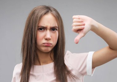 Yaşam tarzı, duygu ve insan konsepti: Güzel genç kadın gri arka plana hayır diyor