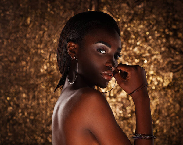 Portrait of beautiful african american female model over golden background.