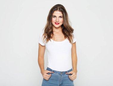 Gri arka planda izole edilmiş güzel sarışın bir kadının stüdyo fotoğrafı..