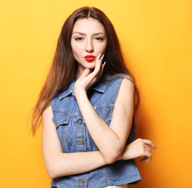 Sarı arka planda izole edilmiş güzel esmer kadının stüdyo fotoğrafı..