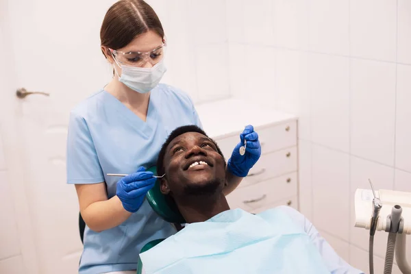 现代门诊部接受牙科治疗的年轻黑人男性患者的画像 — 图库照片