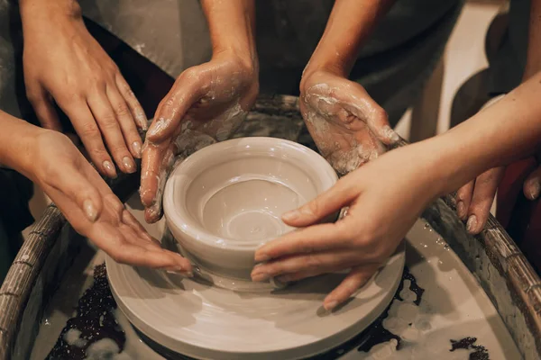 3人の女性が陶器の車輪に取り組んで花瓶を作っています 写真を閉じる — ストック写真