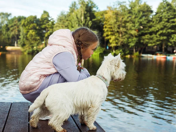 Ein Siebenjähriges Mädchen Mit Einem Kleinen Weißen Hund Steht Auf — Stockfoto