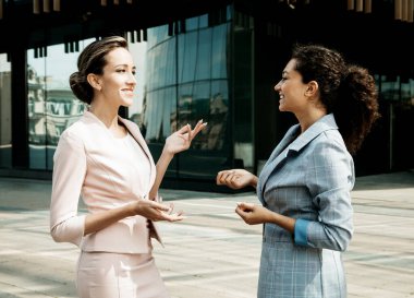 İş, insan ve yaşam tarzı kavramı: iki farklı iş kadını. Heyecanlı afro kadın fikirleri paylaşıyor ya da sarışın kadınla iş planı yapıyor. Gayri resmi sohbet, iş molası kavramı