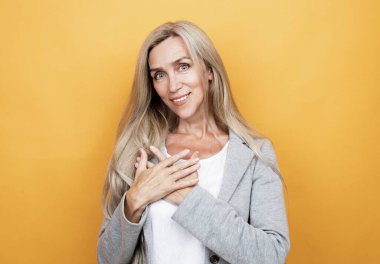 Yaşam tarzı, duygu ve yaşlılar konsepti: Sarı arkaplan üzerinde sarışın iyimser yaşlı kadının portresi