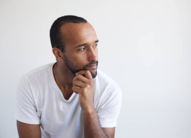 Açık gri arka planda traşsız genç bir adam. Portreyi kapat.