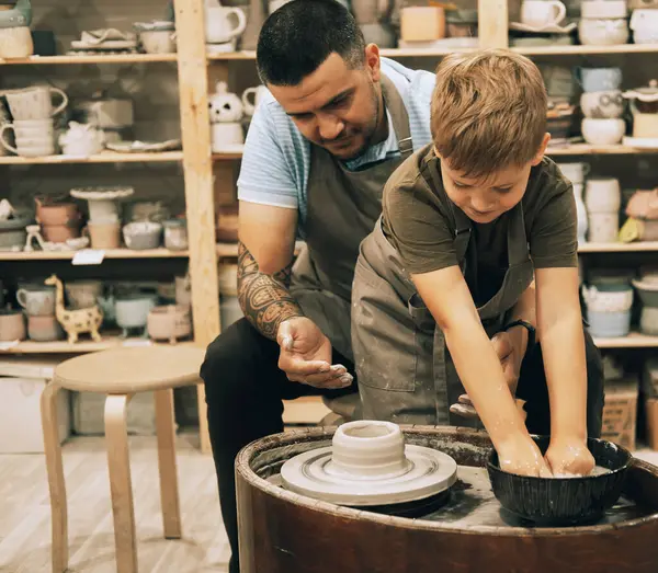 陶器のクラスで陶器の鍋を作る自信のあるハンサムな男と小さな少年 息子と父親は一緒にクリエイティブです — ストック写真