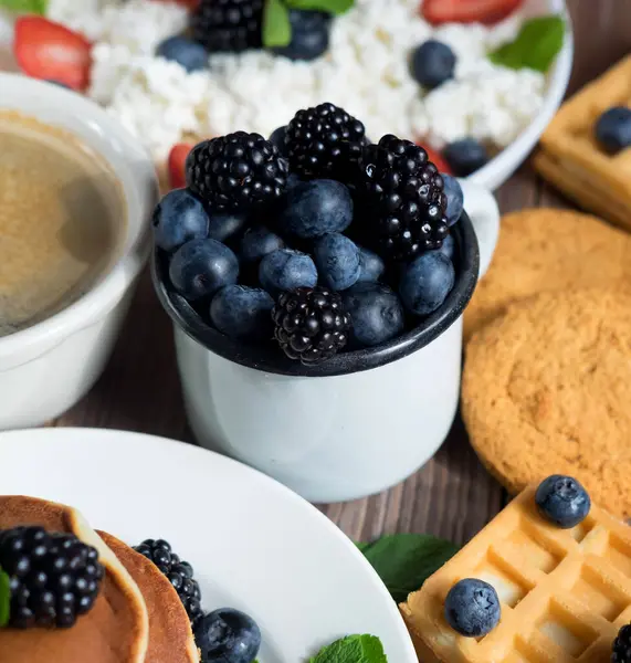 Cup with berries, pancakes, waffles and coffee. Have a good morning tomorrow.