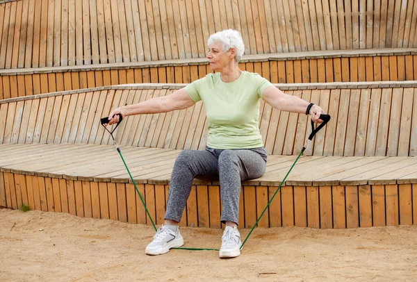 Старая Женщина Короткими Волосами Делает Упражнения Открытом Воздухе Сидя Деревянной — стоковое фото