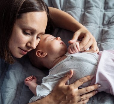 Sevgi dolu anne, yeni doğmuş bebeğini evde taşıyor. Yaşam tarzı ve insan kavramı.